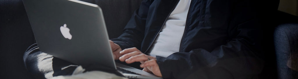 Man wearing FRAHM jacket on laptop