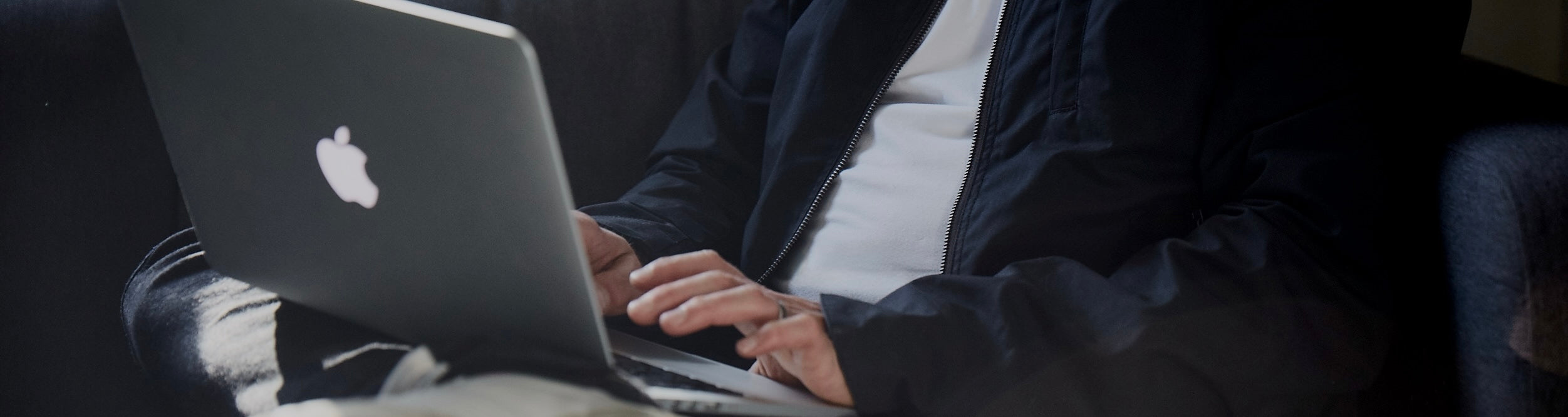 Man wearing FRAHM jacket on laptop