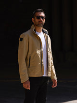 Model wearing FRAHM Harrington Racer Jacket 2026 Desert Beige outdoors in sun
