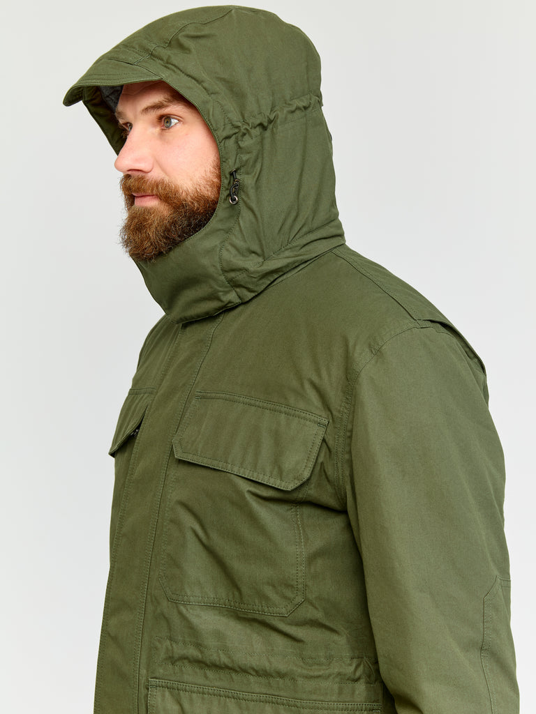 Model wearing FRAHM Ventile Thermal Field 2026 Military Green in studio showing hood detail
