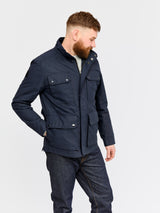 Model wearing FRAHM Waxed Classic Field Jacket 2026 Classic Navy in studio
