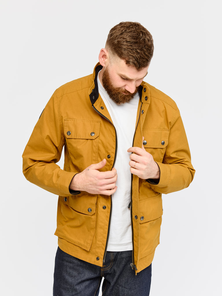 Model wearing FRAHM Waxed Classic Field Jacket 2026 Honey Tan in studio