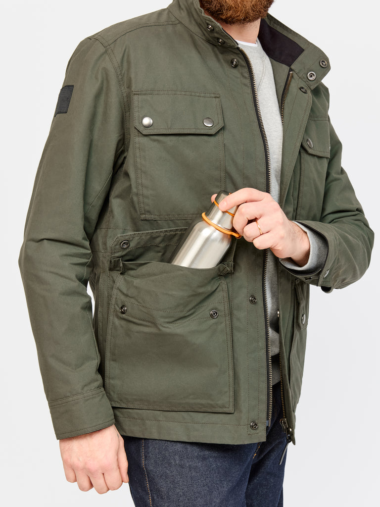 Close up of model wearing  FRAHM Waxed Classic Field Jacket 2026 Dark Olive Green showing pocket details