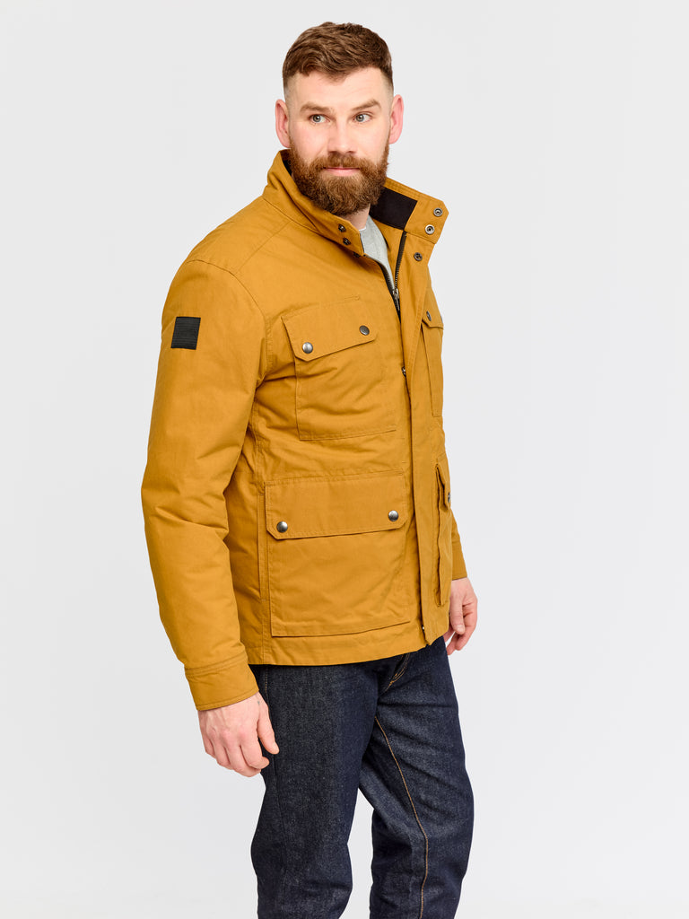 Model wearing FRAHM Waxed Quilted Field Jacket 2026 Honey Tan in studio