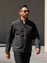 Model wearing FRAHM Harrington Racer Jacket 2027 in Black outdoors