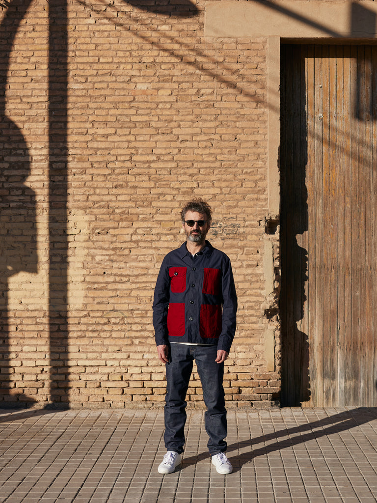 Model wearing FRAHM Waxed Lightweight Workers Jacket 2027 Dark Navy with Red outdoors