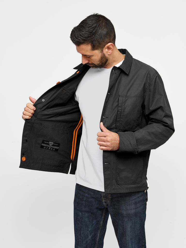 Model wearing FRAHM Original Lightweight Workers Jacket 2027 Black with Orange showing inside of jacket