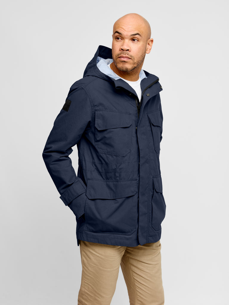 Model wearing Waxed Hooded Field Coat 2027 in Blue indoor