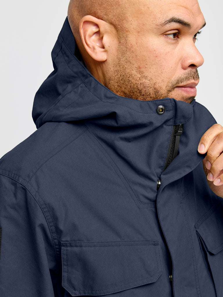Model wearing Waxed Hooded Field Coat in Blue showing hood and collar detail
