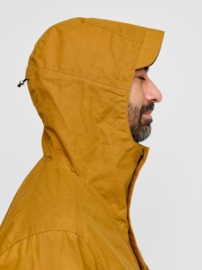 Model wearing Waxed Hooded Field Coat in Honey Tan showing hood detail