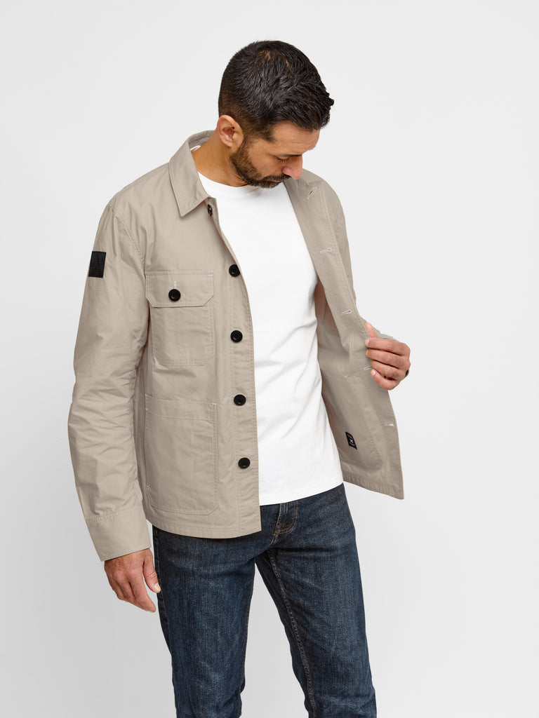 Model wearing FRAHM Waxed Lightweight Workers Jacket 2027 Bath Stone in studio