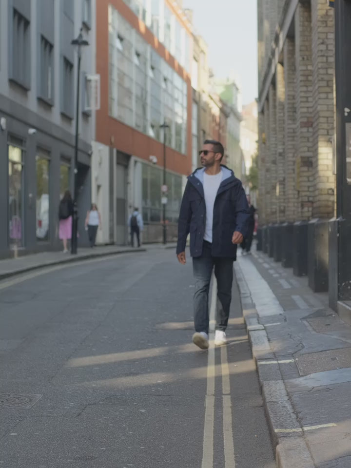 Model wearing Waxed Hooded Field Coat 2027 in Blue outdoors